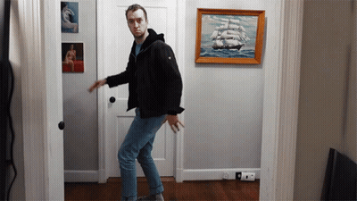 Man In Black Jacket In Front Of Sailboat GIF