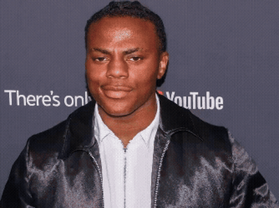Man In Black Jacket In Front Of YouTube Sign GIF