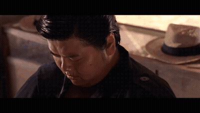 Man In Black Jacket Sitting In Front Of Straw Hat GIF