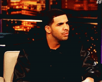 Man In Black Jacket Sitting With EB Letters GIF