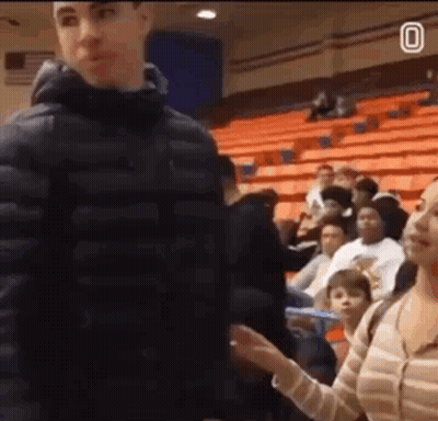 Man In Black Jacket Standing Before Crowd In Auditorium GIF