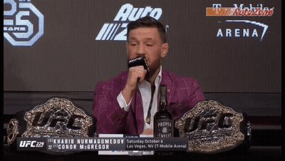 Man In Black Jacket Standing Before Race Day Sign GIF