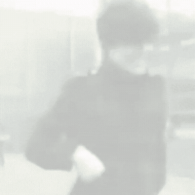 Man In Black Jacket Standing In Front Of Building GIF