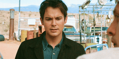 Man In Black Jacket Standing In Front Of Fence GIF