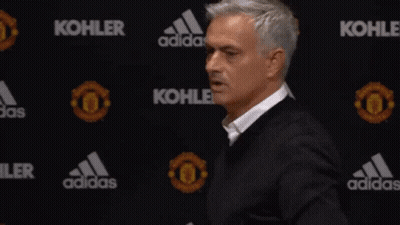 Man In Black Jacket Standing In Front Of Kohler And Adidas Banner GIF
