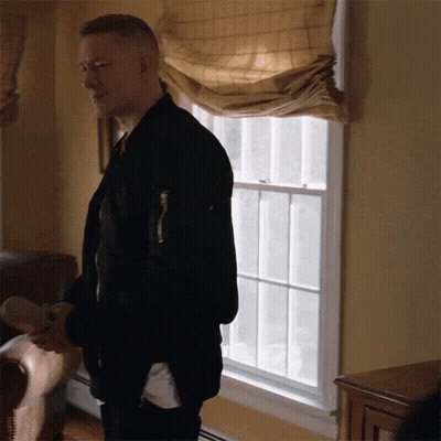Man In Black Jacket Standing In Front Of Window GIF