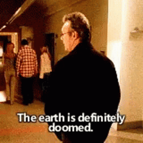 Man In Black Jacket Standing In Hallway Says The Earth Is Definitely Doomed GIF