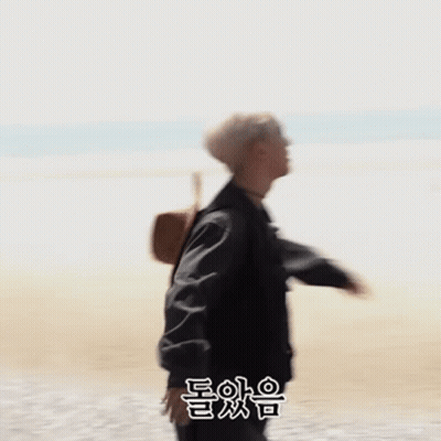 Man In Black Jacket Standing On Beach GIF