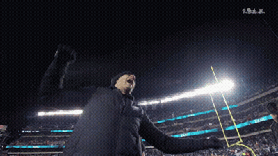 Man In Black Jacket With Fist In Air NFL GIF