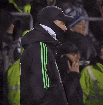 Man In Black Jacket With Green Stripes In Crowd GIF