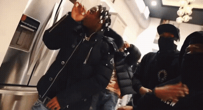 Man In Black Jacket With Letter A In Front Of Refrigerator GIF
