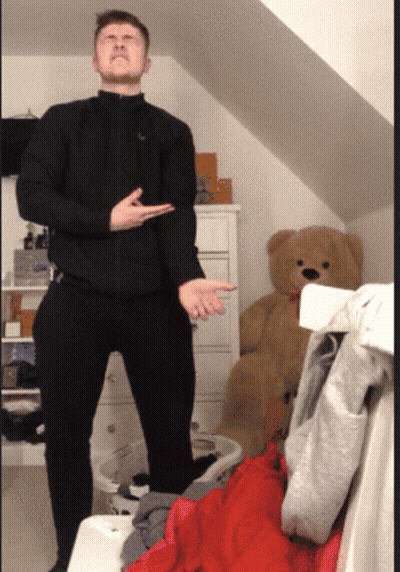 Man In Black Jacket With Teddy Bear In Messy Room GIF