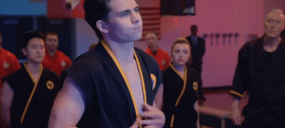 Man In Black Karate Uniform In Gym GIF
