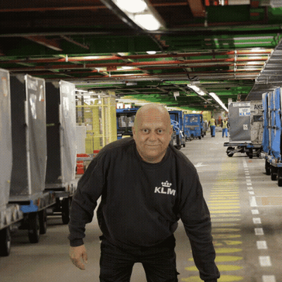 Man In Black KLM Shirt Standing In Warehouse GIF
