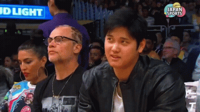 Man in Black Leather Jacket at Basketball Game with Bud Light Sign