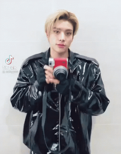 Man In Black Leather Jacket Holding Camera GIF