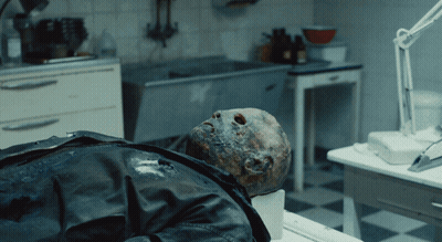 Man In Black Leather Jacket Lying On Table In Dark Room GIF