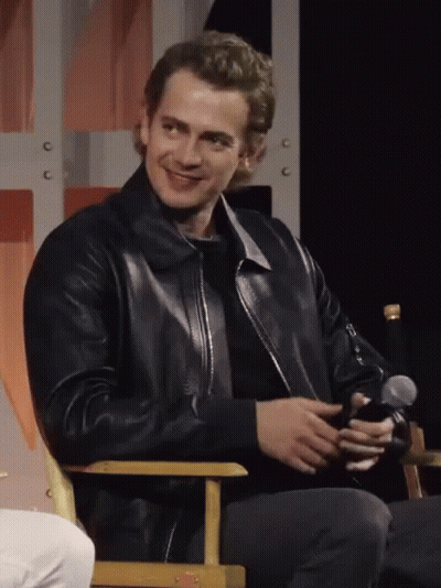 Man In Black Leather Jacket Sitting With Microphone GIF