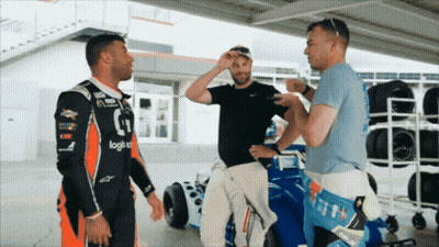 Man In Black Logitech Shirt Talks To Two Men GIF
