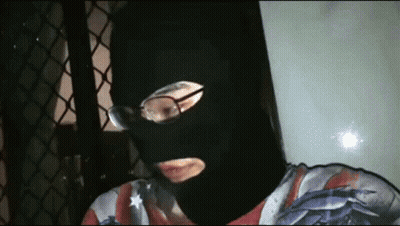 Man In Black Mask And Glasses Looking At Camera GIF