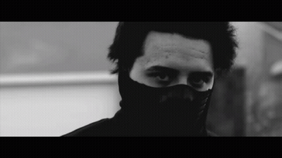 Man in Black Mask Looks at Camera