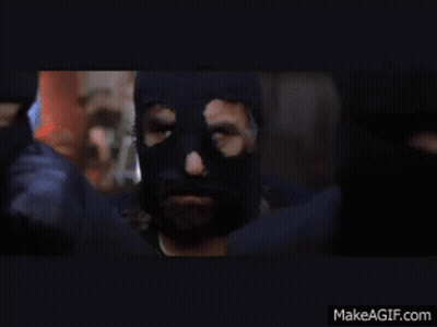 Man In Black Mask Standing Before Crowd GIF