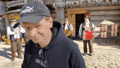 Man In Black Puma Hat With Musicians GIF