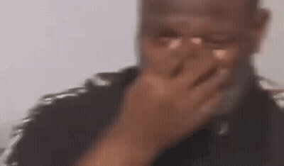 Man In Black Puma Shirt Sitting On Couch Talking To Another Man GIF