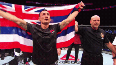 Man In Black Reebok Shirt Holding Hawaiian Flag GIF