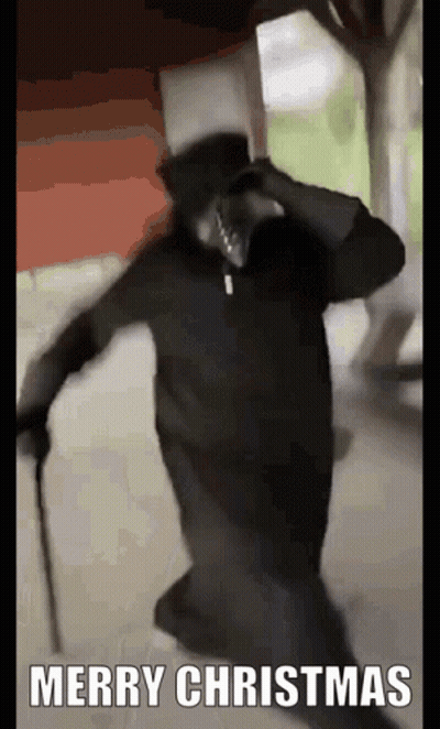 Man In Black Robe And Top Hat Holding Cane Saying Merry Christmas GIF
