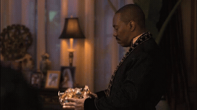 Man In Black Robe Holding Gold Bowl GIF