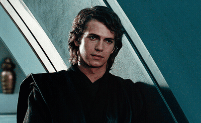 Man In Black Robe In Front Of Blue Wall GIF
