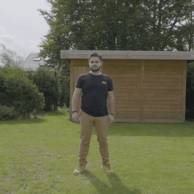 Man in Black SBS T-Shirt by Wooden Shed