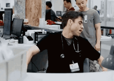 Man In Black Scrub Top With Stethoscope Sitting At Desk GIF