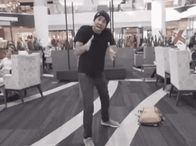 Man In Black Shirt And Beanie Dancing In Mall GIF
