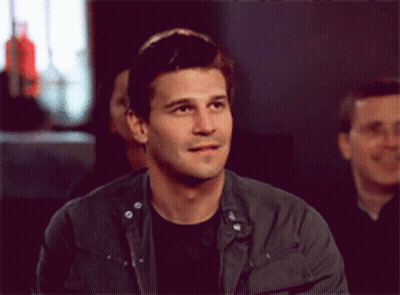 Man In Black Shirt And Grey Jacket Looking At Camera GIF