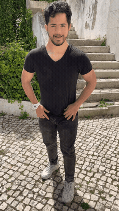 Man In Black Shirt And Jeans Hands On Hips By Stairs GIF
