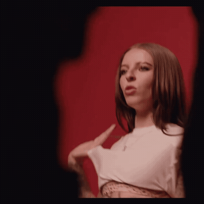 Man In Black Shirt And Necklace Singing At Microphone GIF