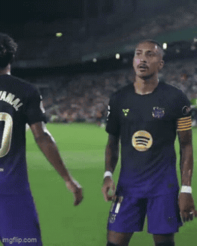 Man In Black Shirt And Purple Shorts Kneeling On Soccer Field GIF