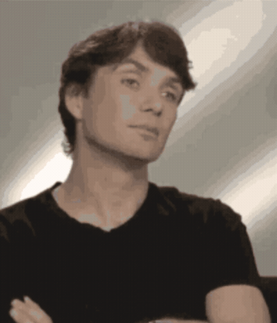 Man In Black Shirt Arms Crossed Looking At Camera GIF