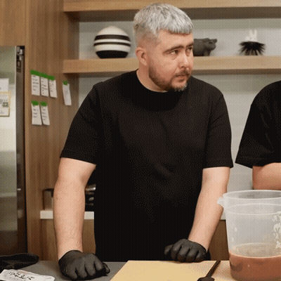 Man In Black Shirt At Cutting Board GIF