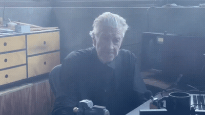 Man In Black Shirt At Desk With Cup GIF