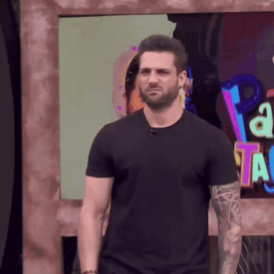 Man In Black Shirt At Sign Saying A GIF