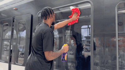 Man In Black Shirt Cleaning Bus With Cloth GIF