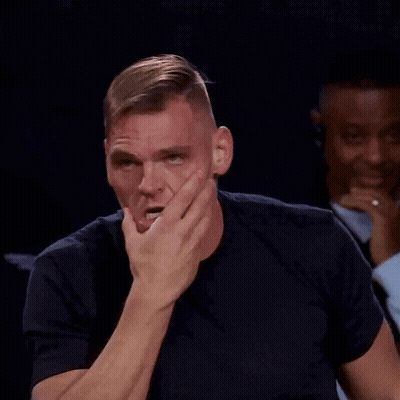 Man In Black Shirt Covering Mouth In Front Of Group GIF