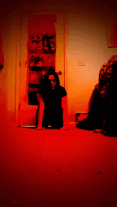 Man In Black Shirt Crawling On Floor In Dark Room GIF