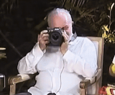 Man In Black Shirt Holding Brazilian Flag In Front Of Crowd GIF