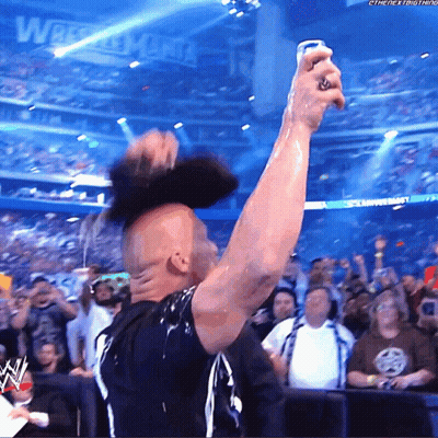 Man In Black Shirt Holding Can In Front Of Wrestlemania Sign GIF