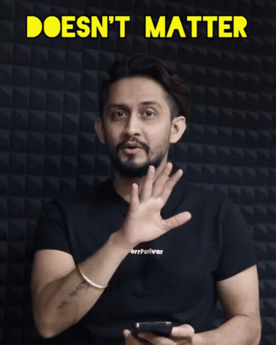Man In Black Shirt Holding Cell Phone In Front Of Doesn't Matter Sign GIF