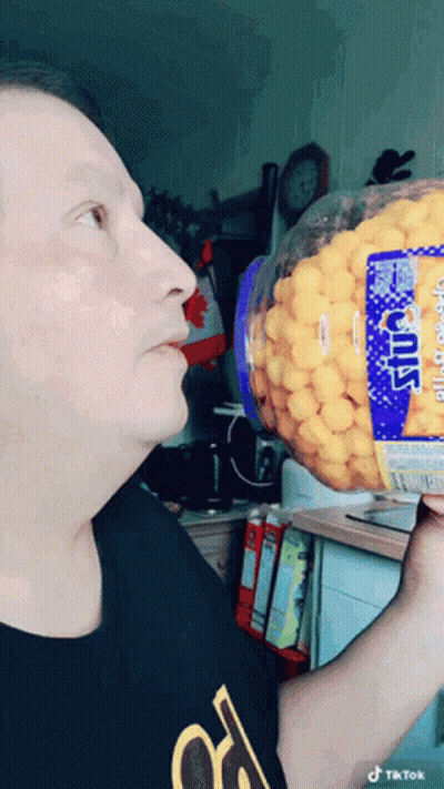 Man In Black Shirt Holding Cheese Puffs GIF